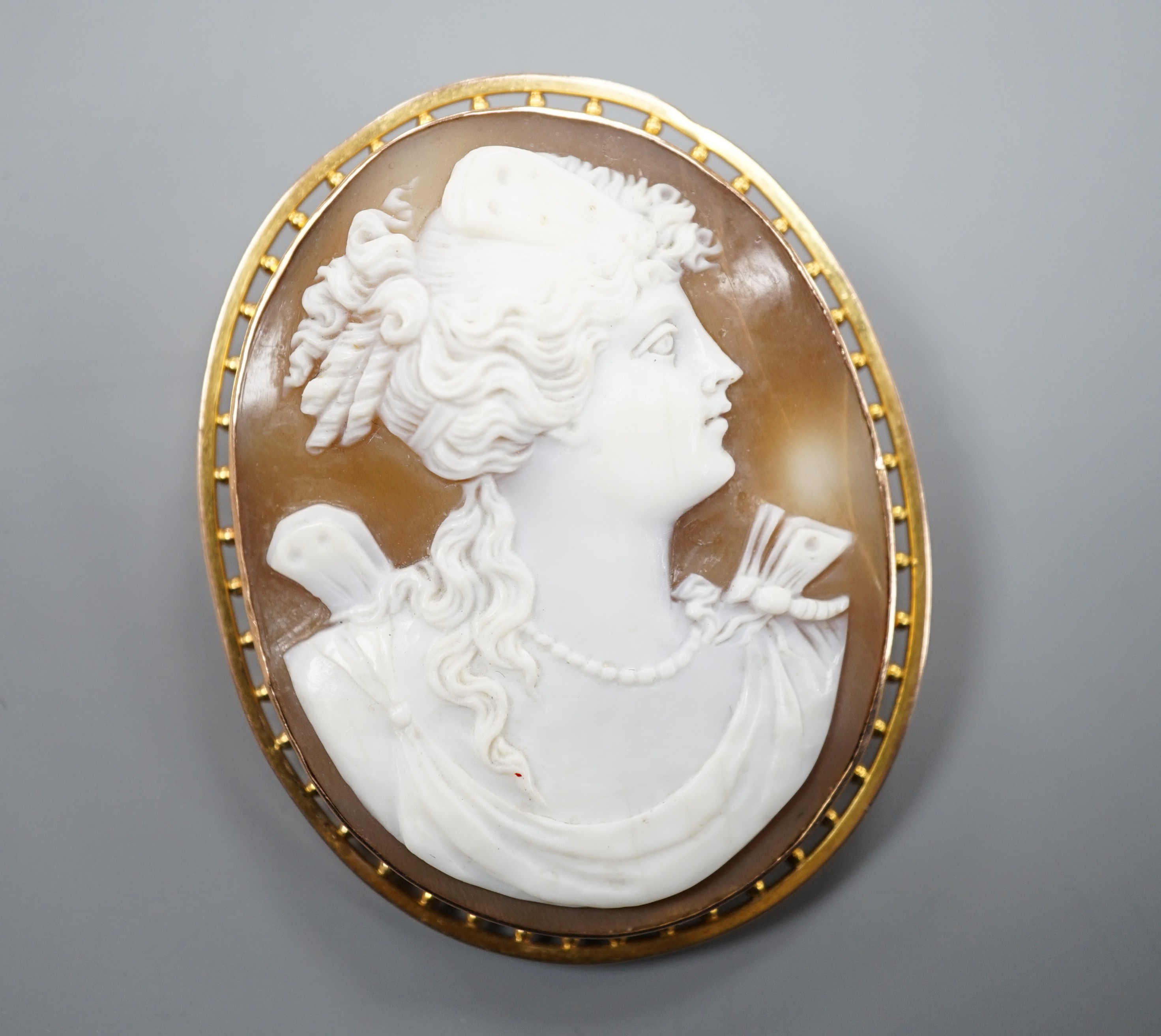 A 9ct mounted oval cameo shell brooch, carved with the bust of a lady to sinister, 5cm, gross weight 11.8 grams.